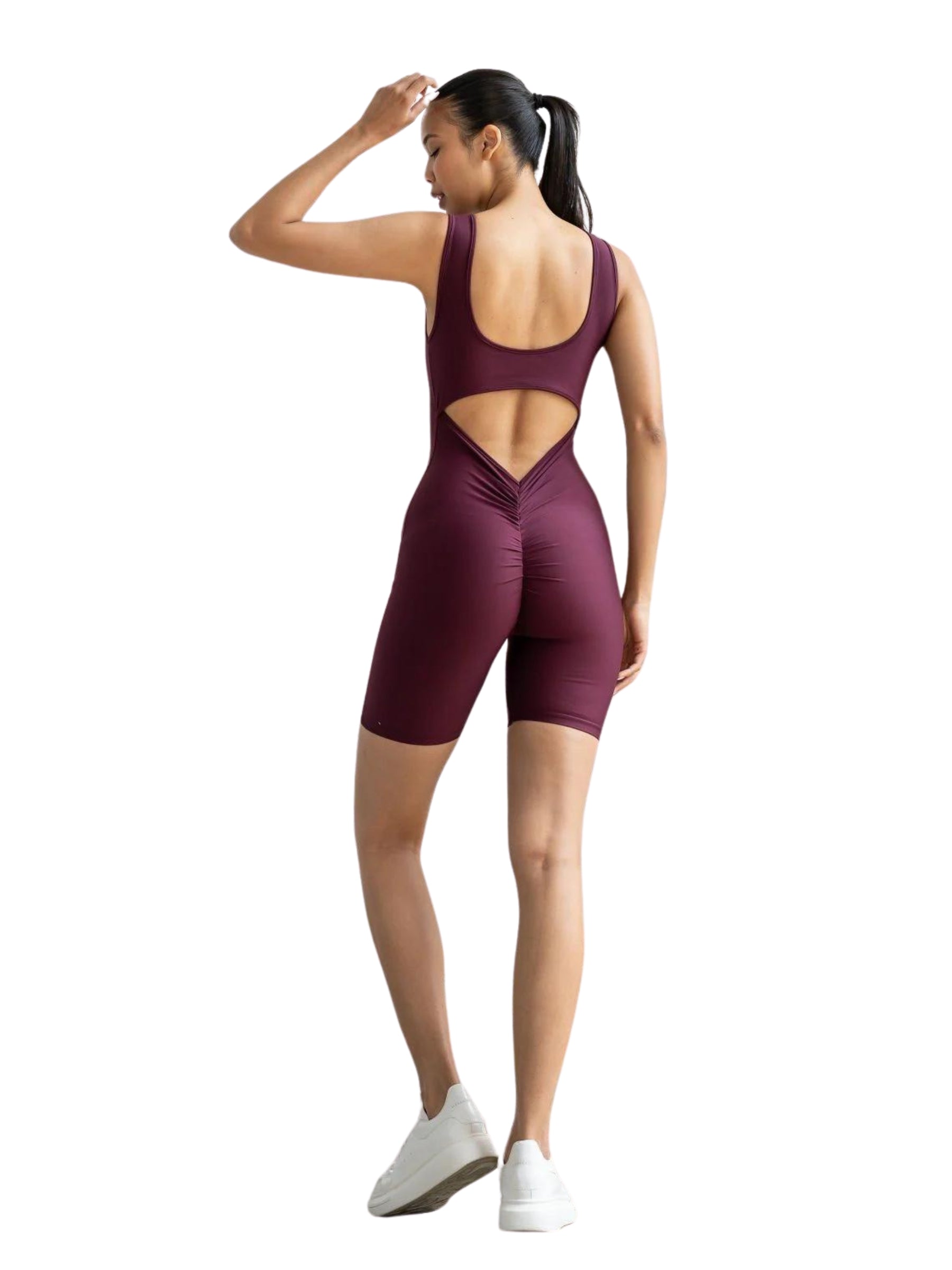 Person in Lisminas 1701 Bordeaux Scrunch Butt Jumpsuit, nach hinten gerichtet, mit Ausschnitt, balanciert auf einem Bein.