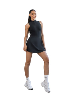 Selbstbewusst im Lismina 3050 Jumpsuit in Schwarz mit Rock-Look und integrierten Shorts vor weißem Hintergrund.