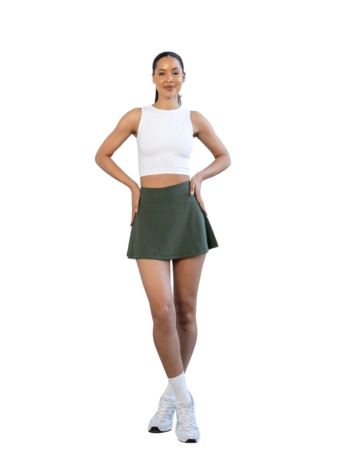 Frau in Lismina 485 Rock in Khaki und weißem ärmellosen Oberteil, stehend vor einem weißen Hintergrund.