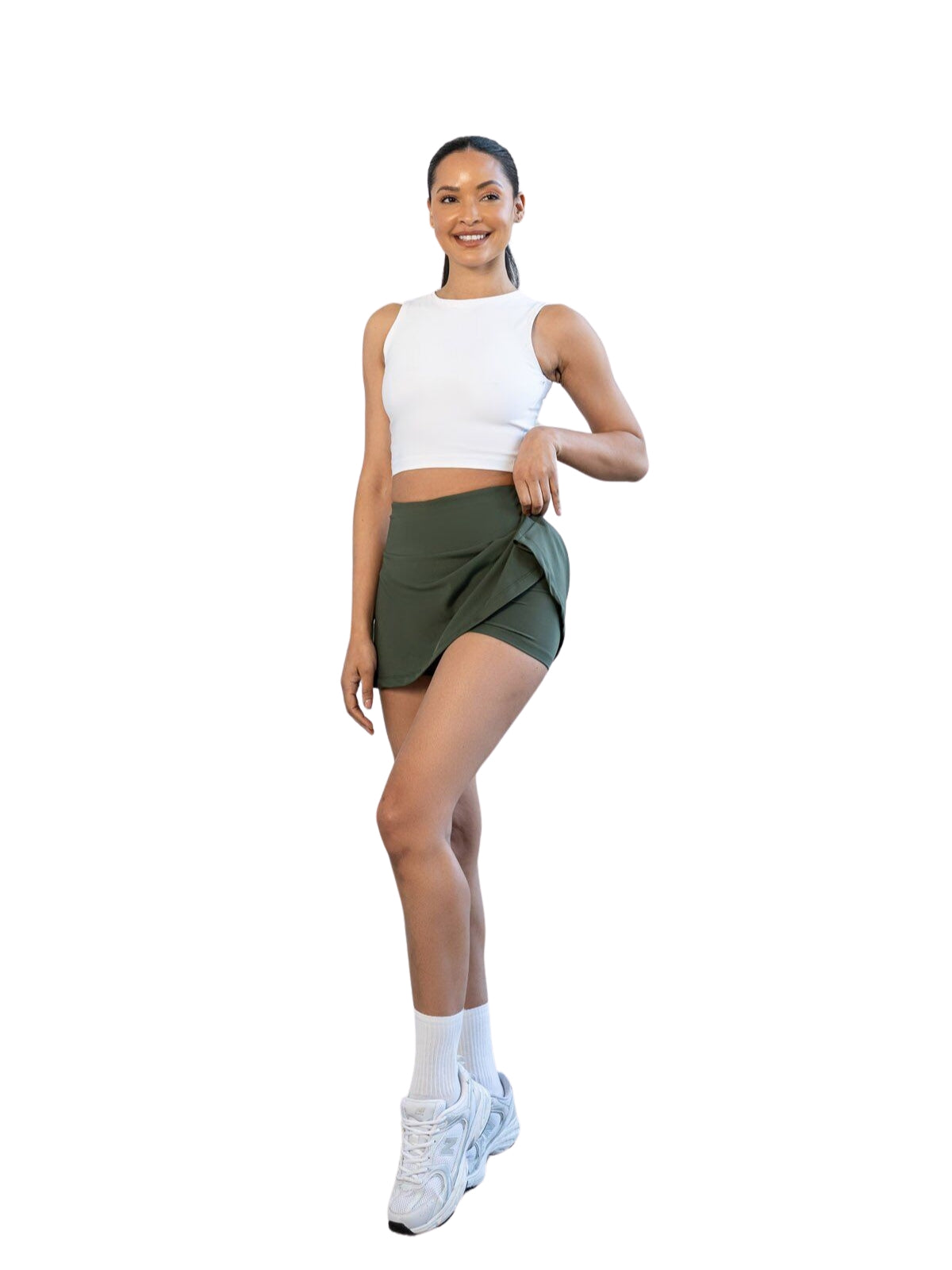 Lächelnde Frau in weißem Crop Top und Lismina 485 Rock in Khaki Skort steht vor einem weißen Hintergrund.