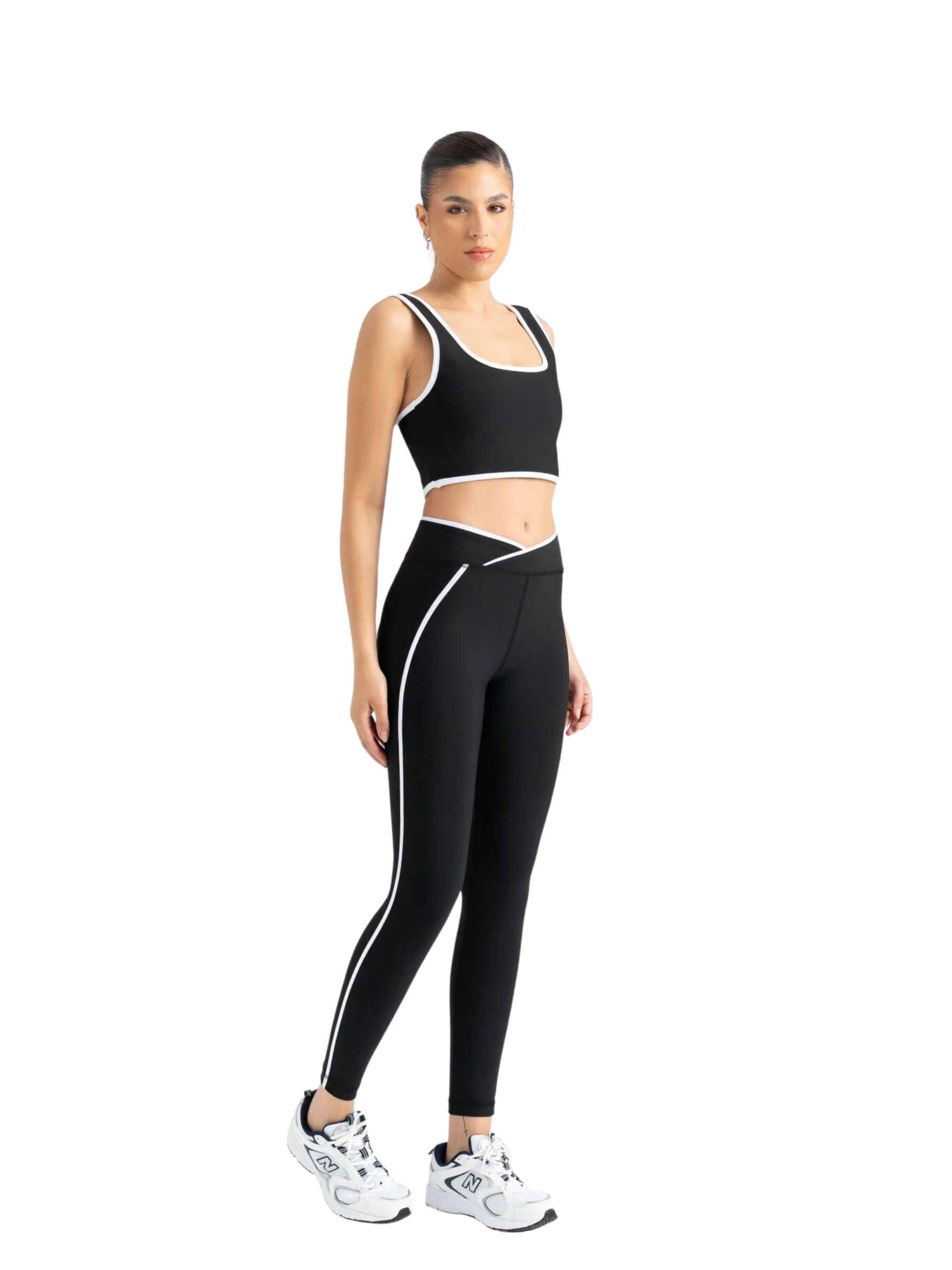 Frau mit Lismina 556 V Line Sport Leggings in Schwarz und Turnschuhen, vor einem schlichten weißen Hintergrund.