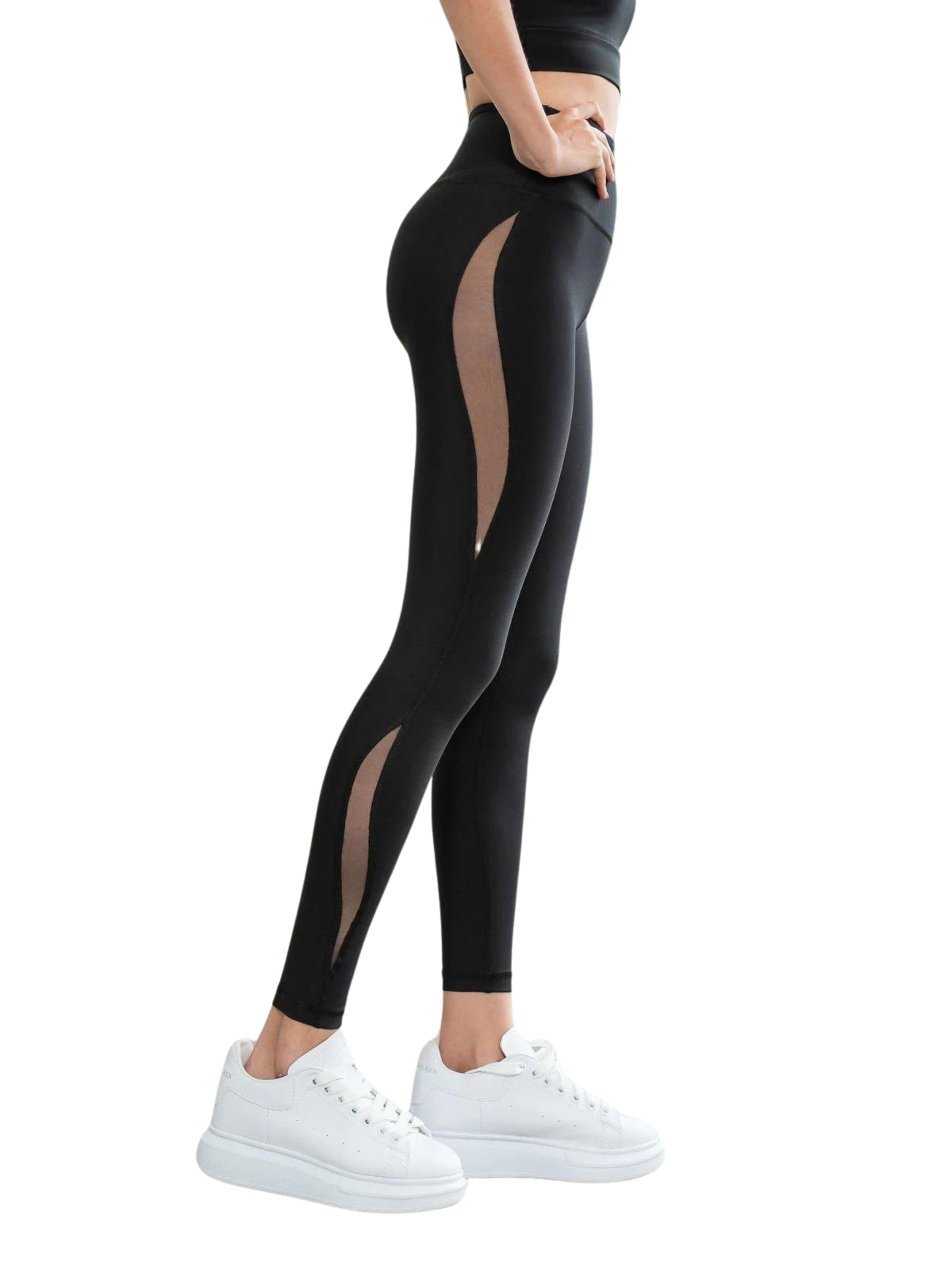 Person in Lisminas 429 High Waist Leggings in Schwarz mit Mesh-Details und weißen Sneakers, posiert von der Seite.