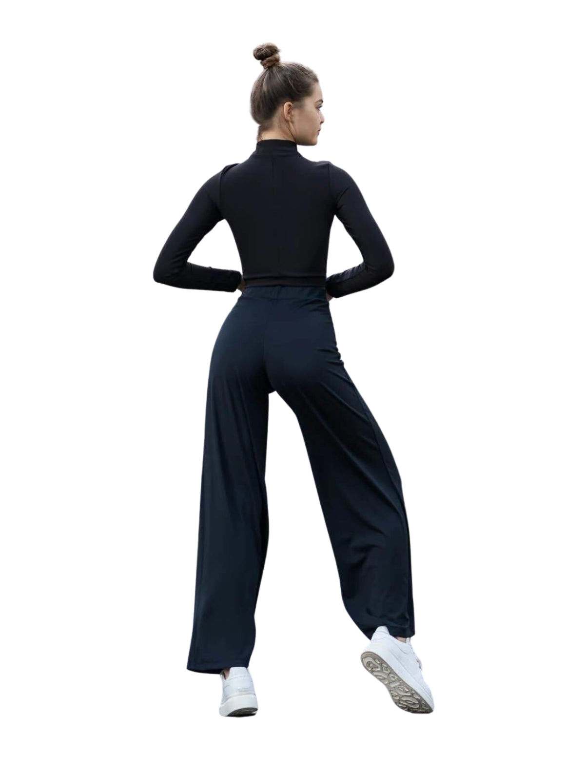 Person in schwarzer Lismina 359 Mumbai Yoga-Hose und weißen Turnschuhen, mit dem Gesicht nach hinten gerichtet vor weißem Hintergrund.