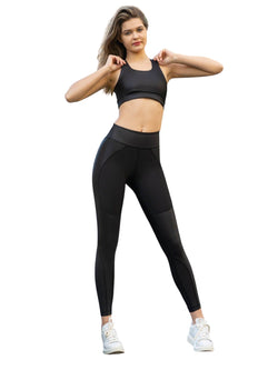 Eine Person posiert selbstbewusst in Lisminas 364 Roses Leggings in Schwarz und einem Sport-BH vor einem weißen Hintergrund.