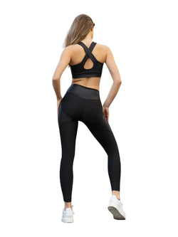 Person in Lismina 364 Roses Leggings in Schwarz und weißen Turnschuhen, mit dem Gesicht abgewandt, vor einem weißen Hintergrund stehend.