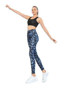 Frau posiert in Lismina 422 Extra High Waist Leggings, schwarzem Sport-BH und weißen Turnschuhen, die Arme ausgestreckt.