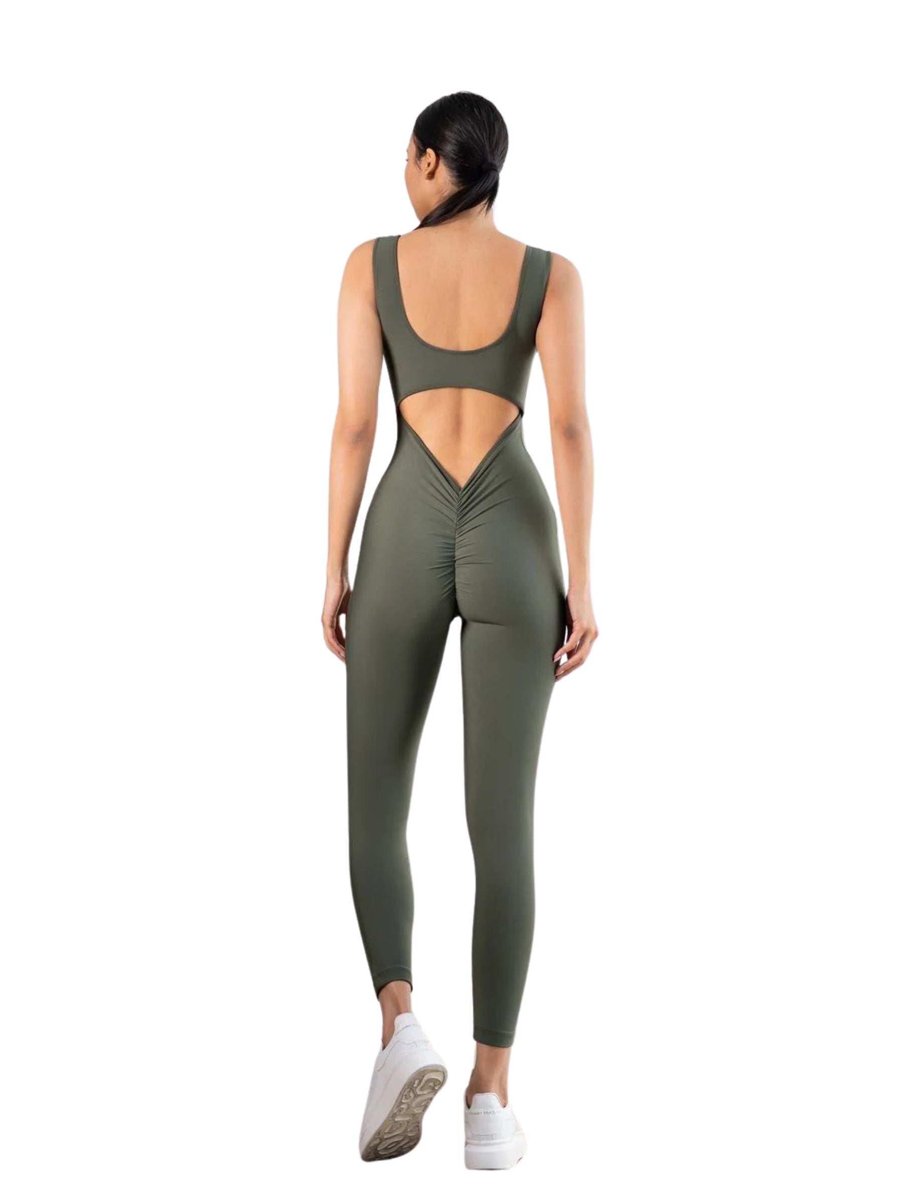 Model im khakifarbenen Scrunch-Butt-Jumpsuit Lismina 1402 mit offenem Rücken, trägt weiße Sneakers auf schlichtem Hintergrund.