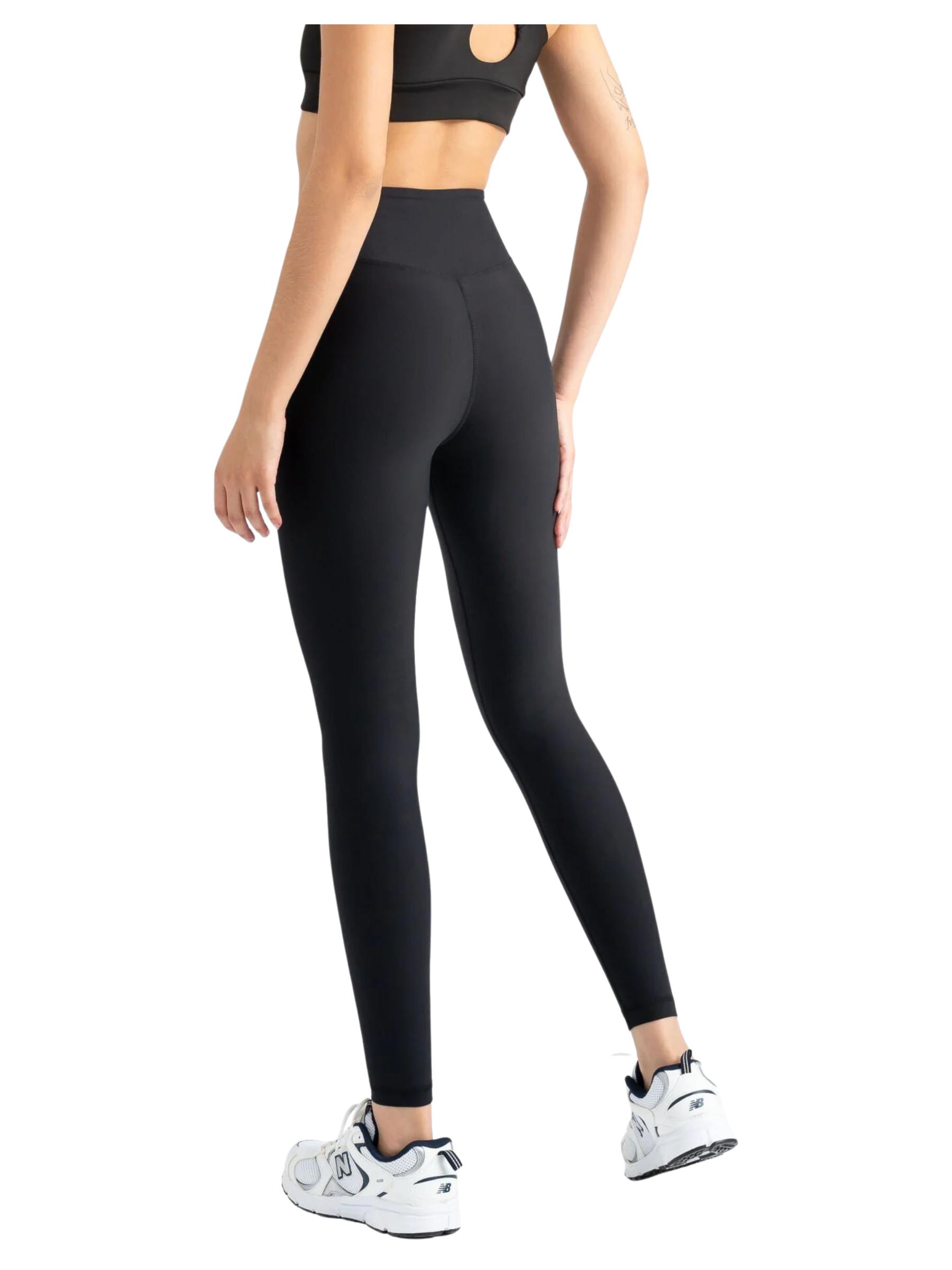 Frau trägt Lismina 408 extra dünne Leggings in Schwarz, Sport-BH und weiße Sneakers, Rücken zur Kamera.