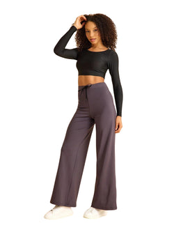 Eine Person in einem schwarzen Crop-Top und Lisminas 446 Mumbai Yoga Hose in Anthrazit posiert vor einem schlichten Hintergrund.