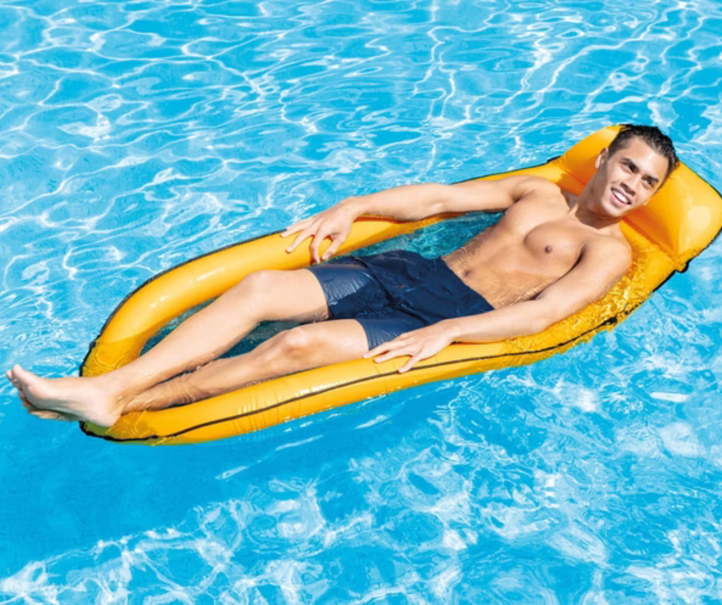 Ein Mann, der auf einer Xinnomix Mesh Lounge Luftmatratze im Pool entspannt, dunkle Badehose trägt und lächelt.