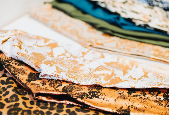 Nahaufnahme verschiedener Stoffmuster mit unterschiedlichen Mustern, darunter Leopardenmuster und metallische Texturen.