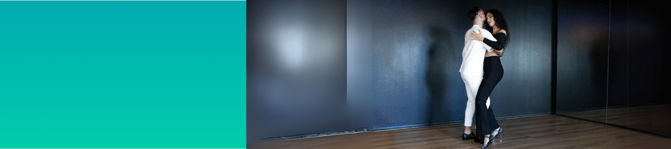 Zwei Menschen tanzen eng umschlungen in einem schwach beleuchteten Raum mit dunkler Wand und reflektierendem Boden.