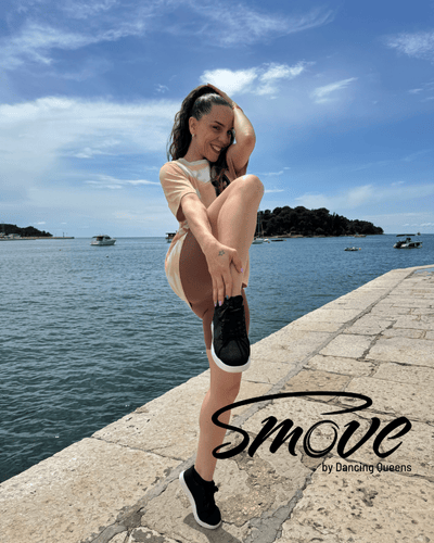 Person macht an einem sonnigen Tag eine Tanzpose am Wasser, mit Booten im Hintergrund. Text: „smove“ von Dancing Queens.