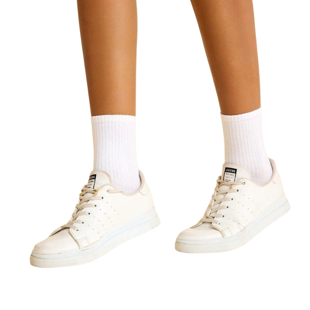 Person in Lisminas weißen Socken 455-4, die auf einem strahlend weißen Hintergrund steht.