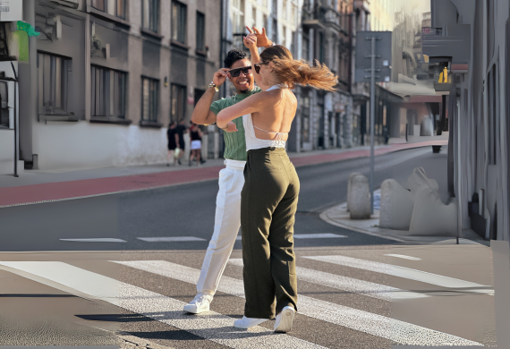 Ein lächelndes Paar tanzt zusammen auf einem Zebrastreifen bei Tageslicht.