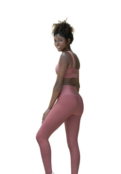 Frau trägt Lisminas 1095 High Waist Leggings in Dunkelrosé und lächelt vor weißem Hintergrund.