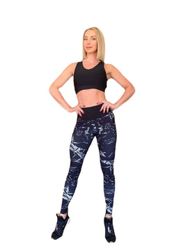 Eine selbstbewusste Frau in Trainingskleidung präsentiert Lisminas schwarzes bauchfreies Top und die 902 Extra High Waist Leggings in Schwarz & Weiß.