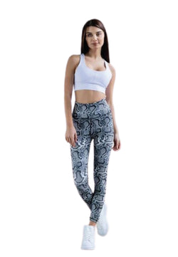 Eine Frau posiert selbstbewusst in Lisminas 280 Extra High Waist Leggings in Grey Snake, kombiniert mit einem weißen Sport-BH und Sneakers.