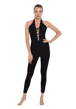 Person in Esmeraldas Lucia Jumpsuit in Schwarz, schicke Schnürung, Neckholder-Ausschnitt, ideal für Yoga, barfuß stehend.