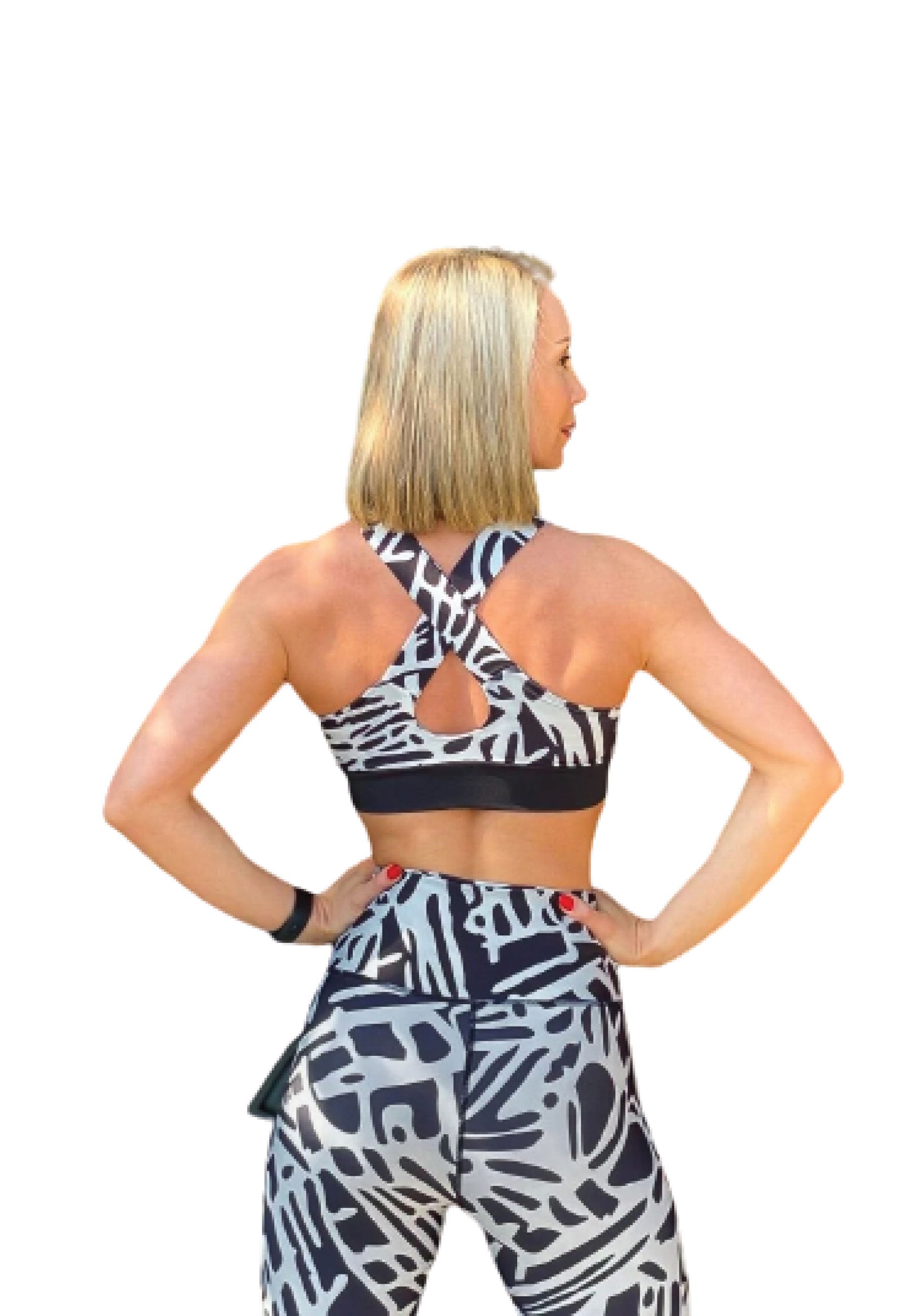 Blonde Person in einem Lismina 172 Sport-BH, schwarz und weiß gemustert, mit dem Gesicht zur Seite, um das Rückendesign zu zeigen.