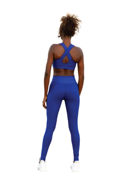 Eine Person in einem Lismina 186 Single Crossed Sport Bra in Blau ist von hinten vor einem weißen Hintergrund zu sehen.