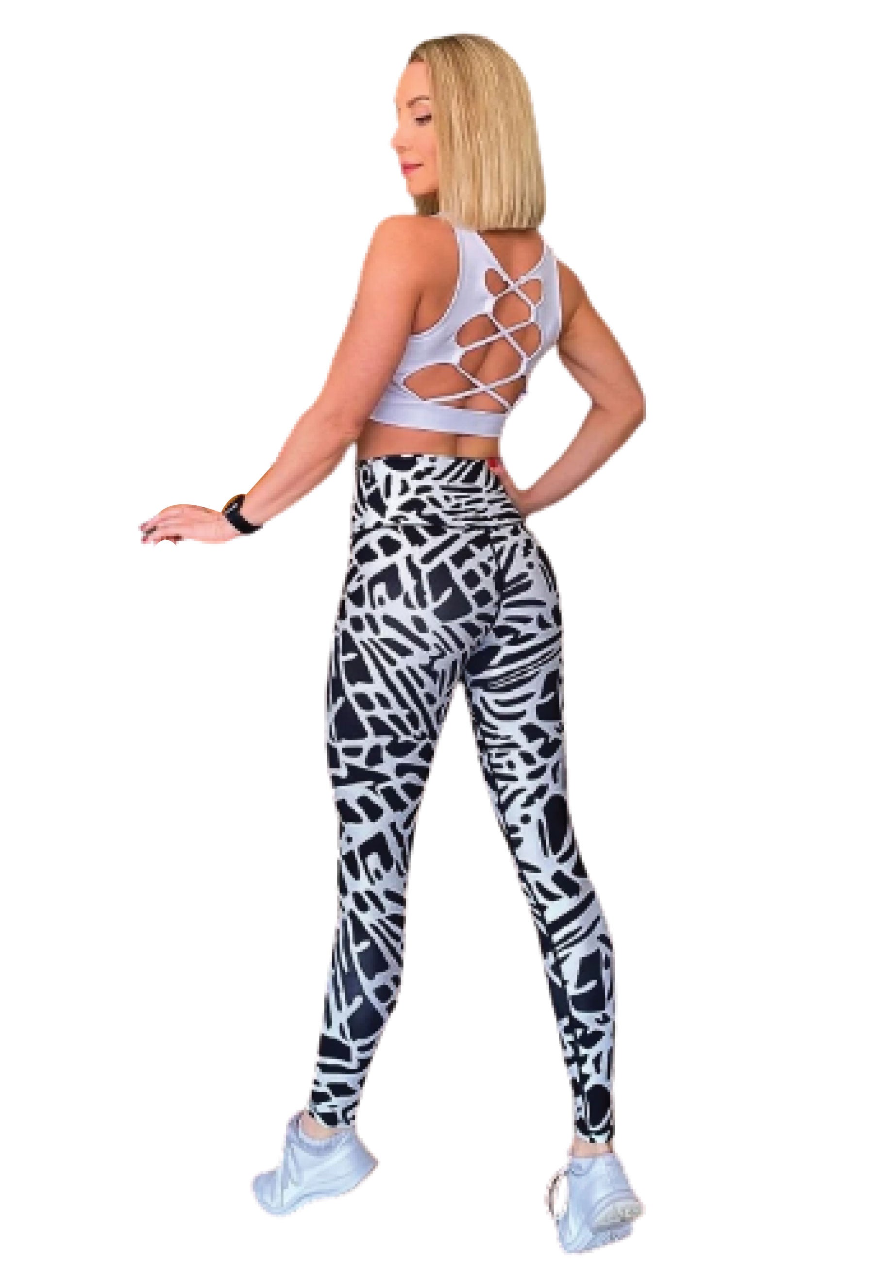 Eine Frau posiert seitlich in einem weißen Top und Lisminas 906 Extra High Waist Leggings in Schwarz & Weiss mit weißen Sneakers.