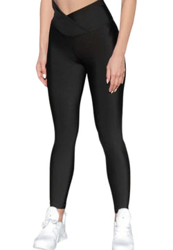 Eine Frau in Lisminas 1033 Extra High Waist Leggings (Schwarz) und weißen Sneakers steht vor einem weißen Hintergrund.