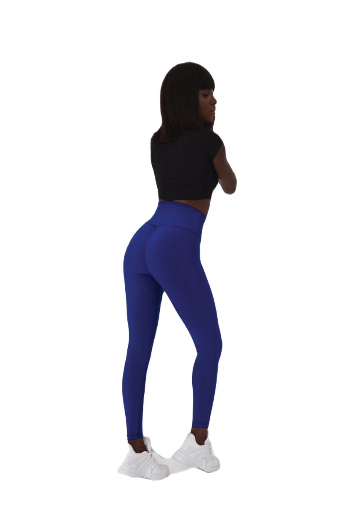 Person in einem schwarzen bauchfreien Top, die Lismina 738 Scrunch Butt Leggings in Royalblau trägt und seitlich in weißen Turnschuhen steht.
