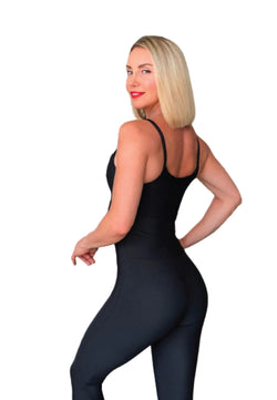 Model in einem schwarzen Jumpsuit von Lismina 2700 posiert mit der Hand auf der Hüfte und blickt über die Schulter.