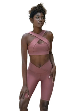 Eine Person in Lisminas Dark Rose 6027 Biker-Leggings und einem rosa Ve Waist-Top posiert selbstbewusst vor einem weißen Hintergrund.