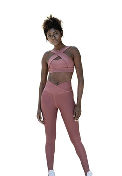Person in Lisminas 1100 Ve Waist Leggings in Dunkelrosa und weißen Turnschuhen, bereit für Yoga vor einem weißen Hintergrund.