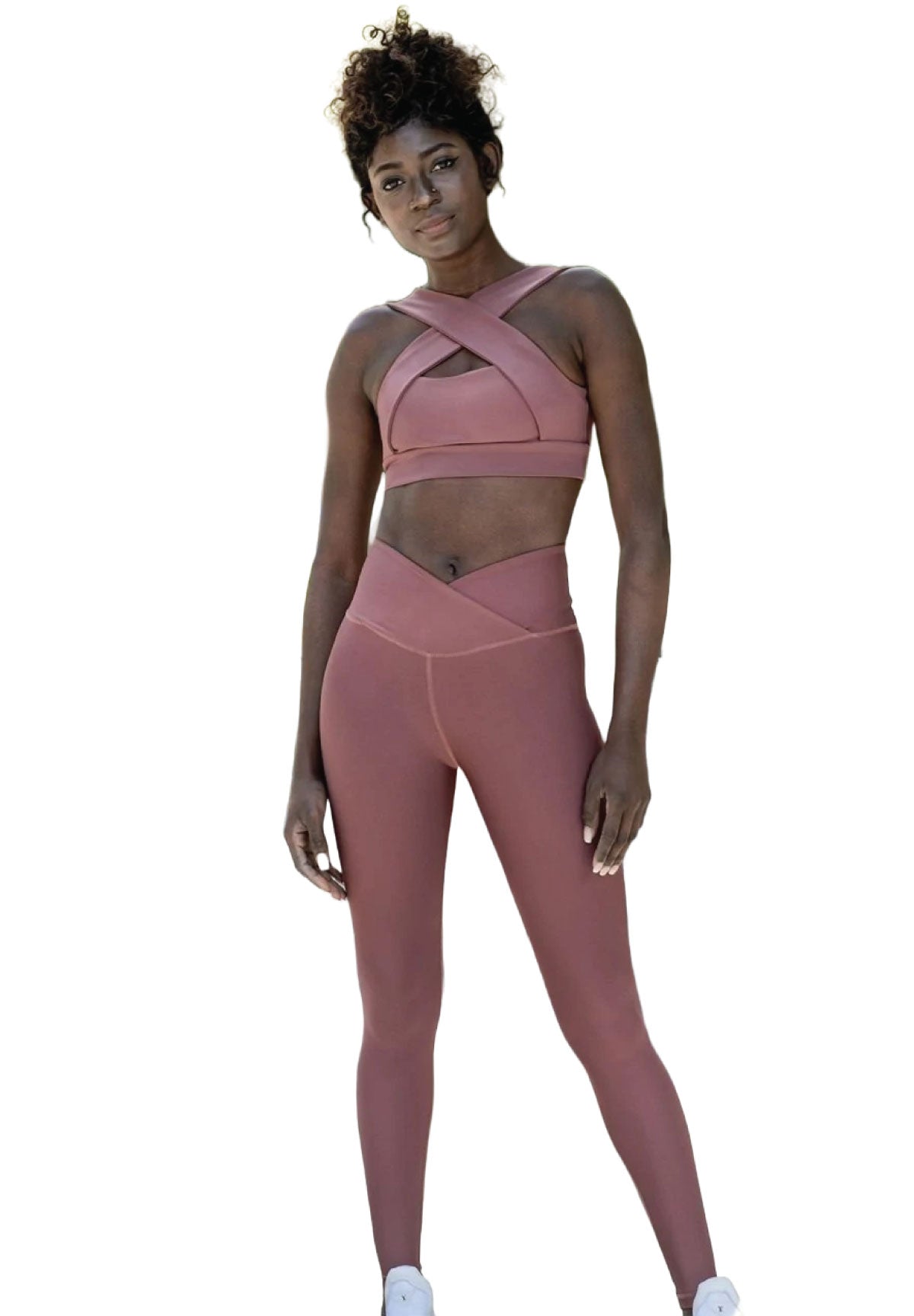 Person in Lisminas 208 Decoltée Sport-BH in Dunkelrosa und Leggings, die Fitness vor einem weißen Hintergrund verkörpert.