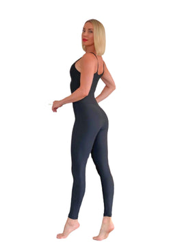 Person in Lisminas 2700 schwarzem Jumpsuit, barfuß, zur Seite gedreht mit kurzen blonden Haaren.