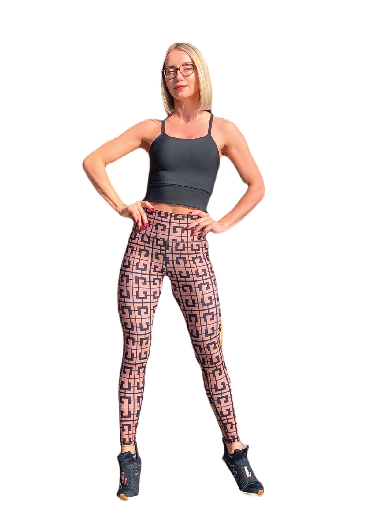 Frau in schwarzem Top und 869 Extra High Waist Leggings von Lismina steht selbstbewusst, die Hände in die Hüften gestemmt, trägt eine Brille.