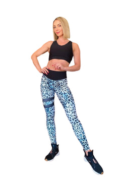 Eine selbstbewusste Person in einem schwarzen bauchfreien Top und Lismina 903 Leggings mit extra hoher Taille in Leopardenmuster trägt schwarze Turnschuhe.