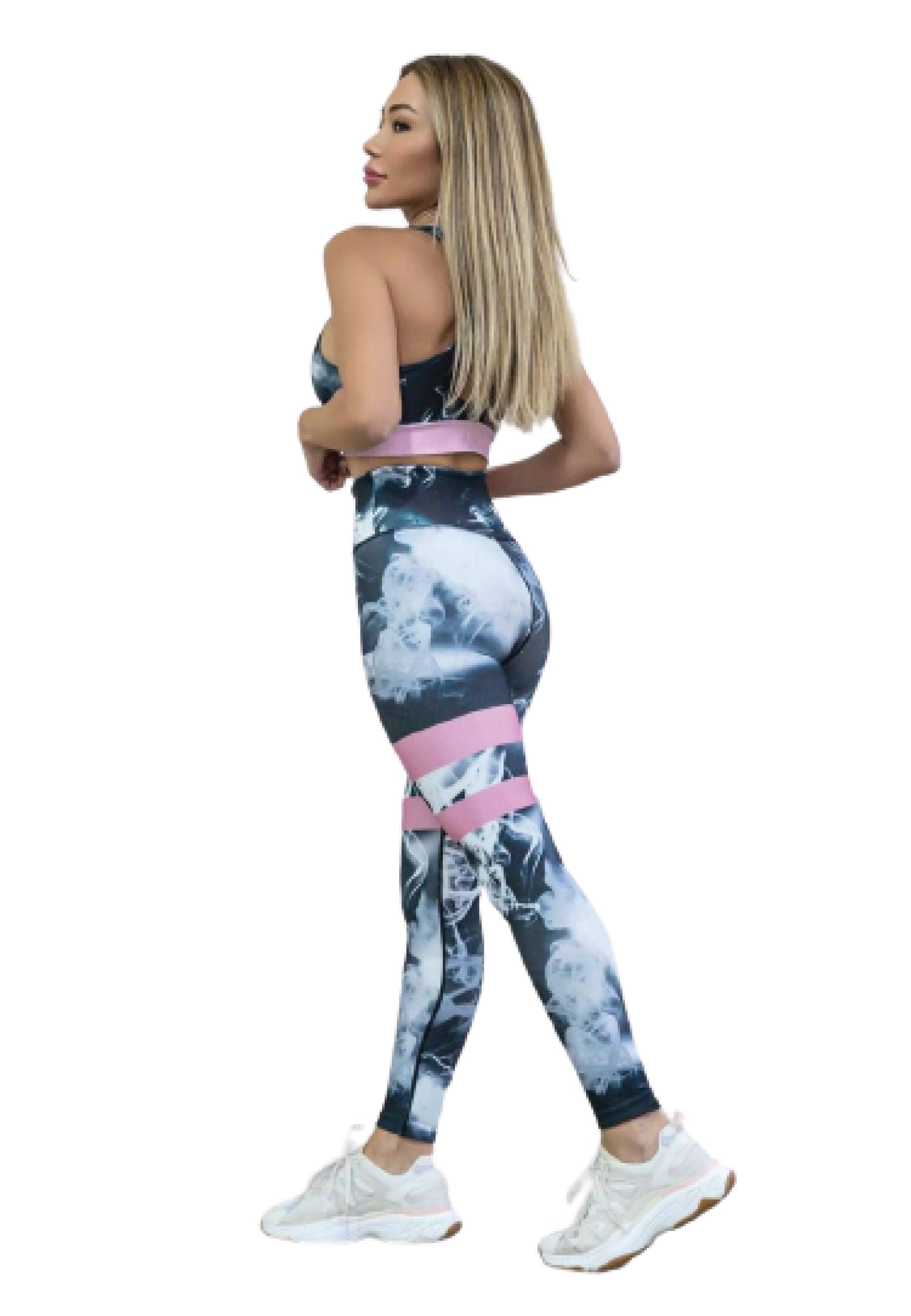 Person in Lisminas 284 Extra High Waist Leggings, geblümter Trainingskleidung und weißen Turnschuhen beim Yoga.