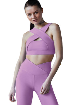 Person in hellvioletter Sportkleidung „Lismina“ mit gekreuzten Trägern und 1044 Extra High Waist Leggings in Lila, die selbstbewusst posiert.