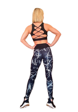 Eine Person in einem überkreuzten Sport-BH und Lismina 902 Extra High Waist Leggings steht mit den Händen auf den Hüften und blickt weg.