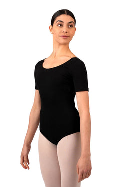Person im schwarzen Trikot R3100 von Rumpf und hellen Strumpfhosen, steht vor einem weißen Hintergrund und blickt zur Seite.