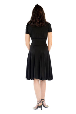 Eine Frau trägt das RU5751 Augusta Kurzarm-Kleid von Rumpf und steht vor einem weißen Hintergrund.