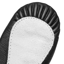 Nahaufnahme eines 1001 Ballettschläppchens aus Leder mit schwarzer Sohle von Rumpf, einem weißen Wildlederfleck und detaillierten Nähten.