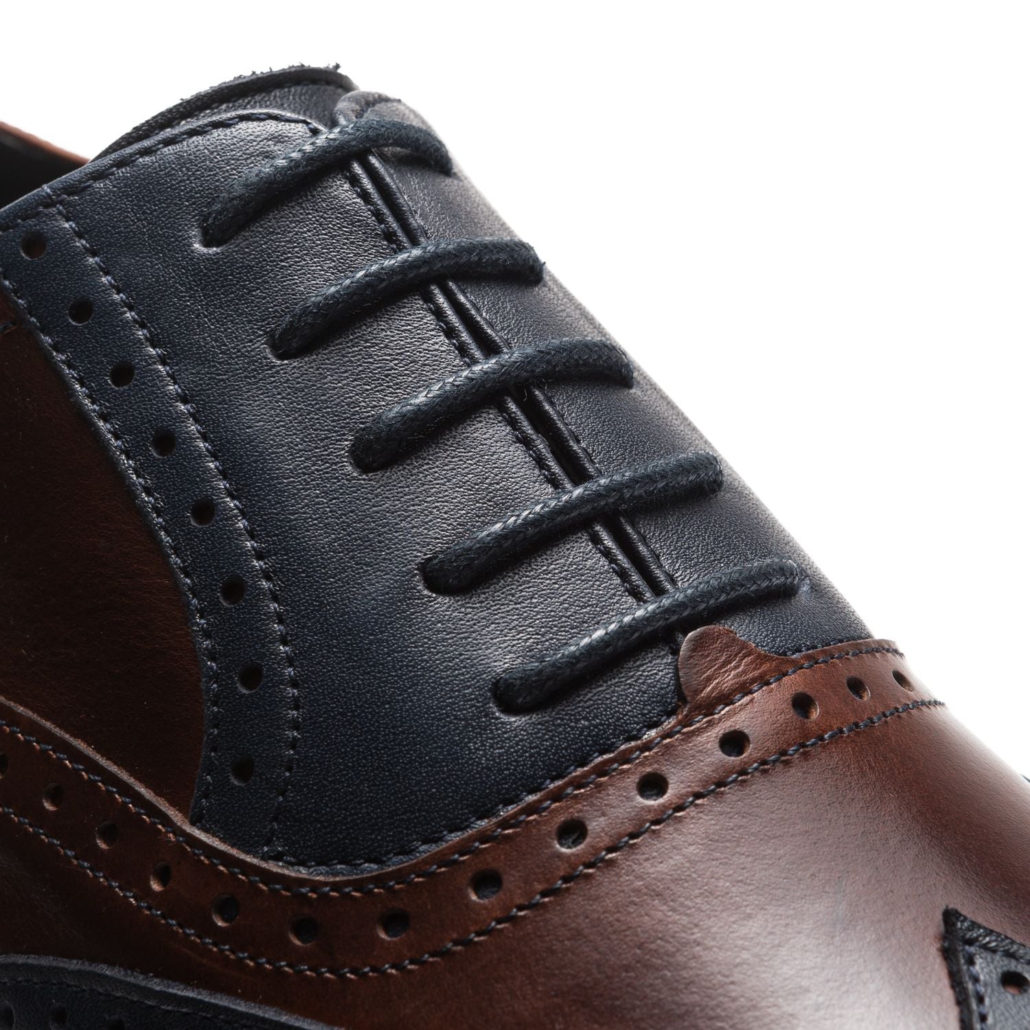 Nahaufnahme von Rumpfs 2158 Ruben Tanzschuhen in Dunkelblau und Braun mit schwarzen Schnürsenkeln und aufwendigen Perforationen.