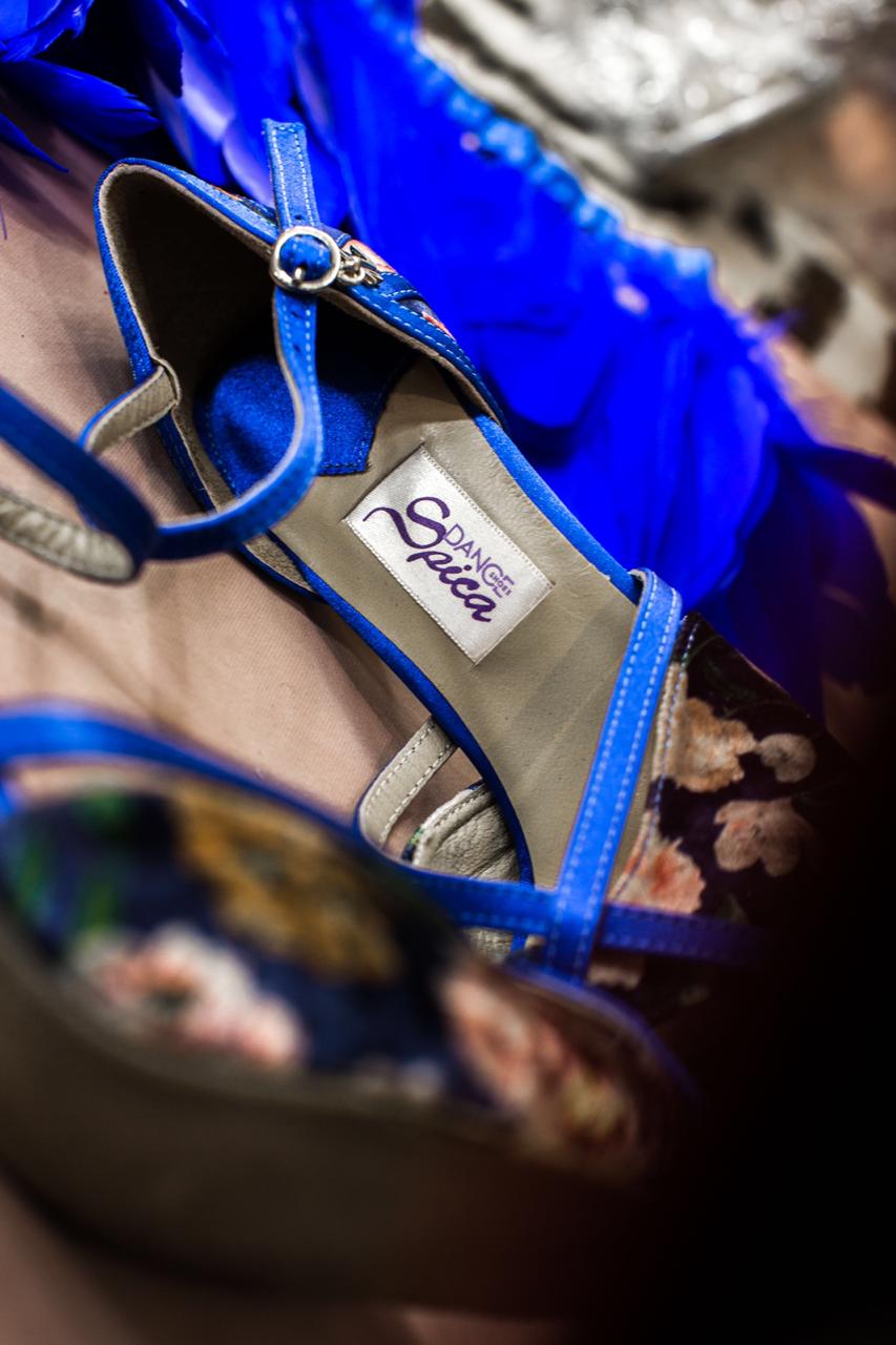 Auf dem unscharfen Hintergrund sind „Naos Tanzschuhe in Blau geblumt“ von Dancing Queens zu sehen – ein blauer Tanzschuh aus Satin mit Blumenmuster.