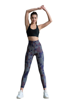 Eine Person in Trainingskleidung macht Dehnübungen. Sie trägt einen schwarzen Sport-BH, Leggings 327 Braun von Lismina und weiße Turnschuhe.