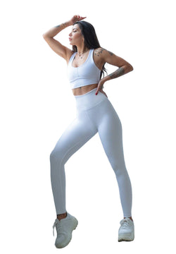 Person, die in Lisminas 314 Winter High Waist Leggings in Weiss und weißer Sportbekleidung posiert und Tattoos zur Schau stellt.