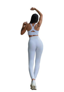 Person in Lisminas 314 Winter High Waist Leggings in Weiss, Arme nach oben, zeigt Rückentattoo, bereit für Outdoor-Sport.