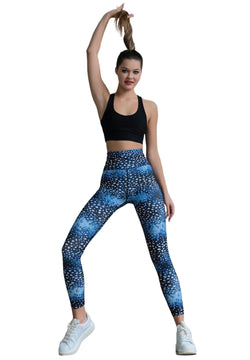 Eine Lismina-Kundin, die ein schwarzes Sporttop und 325 Extra High Waist Leggings in Blau trägt, praktiziert Yoga auf einem Bein.