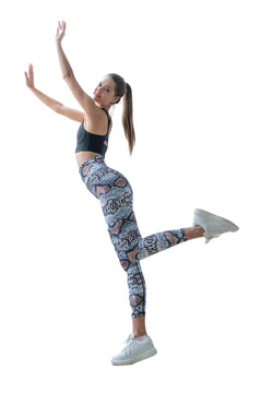 Eine Frau präsentiert Lisminas 328 Extra High Waist Leggings in Braun und Blau und nimmt eine dynamische Pose vor einem weißen Hintergrund ein.