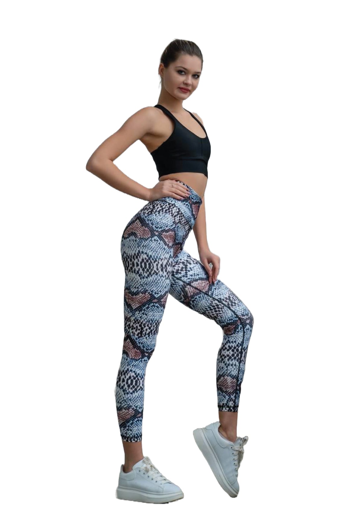 Eine Frau in einem schwarzen Sport-BH und Lisminas 328 Extra High Waist Leggings posiert selbstbewusst in weißen Sneakers.