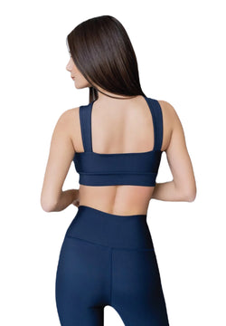 Eine Frau in marineblauen Lismina 296 Extra High Waist Leggings, von hinten gesehen, mit langen braunen Haaren, schaut zur Seite.
